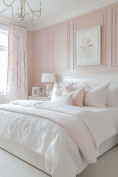 a bedroom with pink walls, white bedding and chandelier hanging from the ceiling