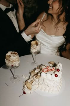 a man and woman sitting at a table with a cake