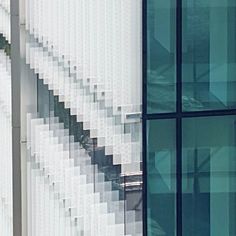 a clock is on the side of a building with many windows in front of it