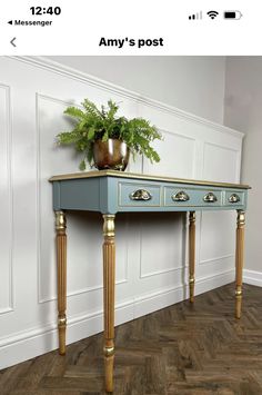 a blue table with gold legs and a potted plant on top