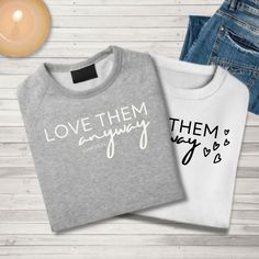 three sweaters with the words love them and they are next to each other on a white wooden surface