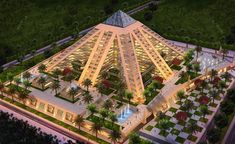 an aerial view of a large building surrounded by palm trees and greenery at night