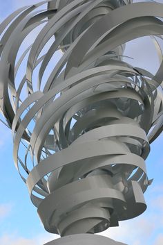 an abstract sculpture is shown against a blue sky