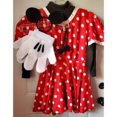 a minnie mouse dress and gloves hanging on a door