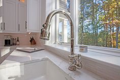 a kitchen sink sitting under a window next to a counter top