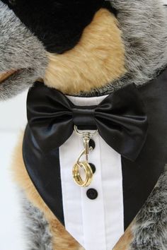 a teddy bear wearing a tuxedo with a ring on it's collar