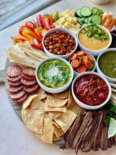 a platter filled with different kinds of food and dips on top of each other