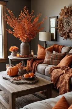 a living room filled with lots of furniture and fall decorations on top of it's coffee table