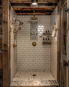 a walk in shower sitting next to a wooden wall and ceiling with exposed lighting above it