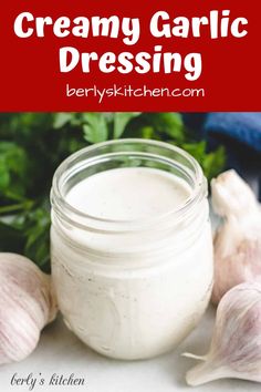 creamy garlic dressing in a jar with fresh herbs around it