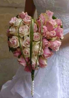 a bride holding a bouquet of pink roses