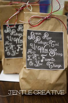 two brown paper bags sitting on top of a wooden table covered in chalk and twine