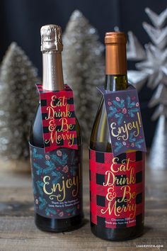 two bottles of wine sitting next to each other on top of a wooden table in front of a christmas tree