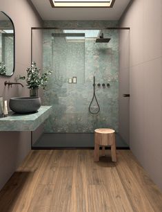 a bathroom with a skylight and wooden flooring, along with a walk in shower