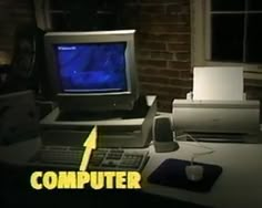 an old computer sitting on top of a desk in front of a window with the words computer over it