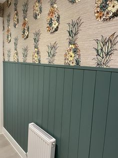 there is a wall with pineapples on it and a radiator in the corner