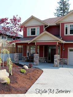 a large red house with lots of windows and landscaping around the front yard area is shown