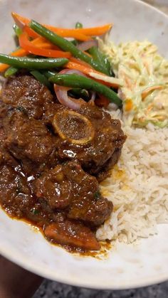 a white plate topped with meat, rice and veggies