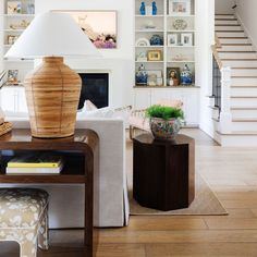 a living room filled with furniture and a large lamp on top of a wooden table