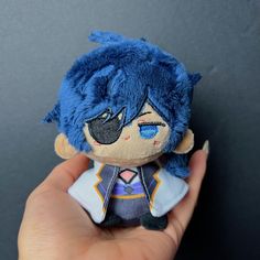 a person holding a small stuffed animal in their left hand and wearing a blue outfit