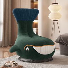 a living room with a chair shaped like a whale and a cat sleeping on the floor