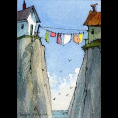 there are clothes hanging out to dry on the line in front of some houses and cliffs