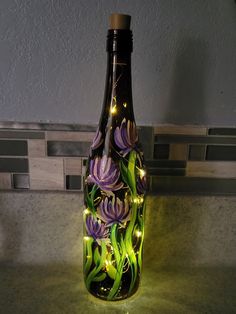 a glass bottle with lights in it sitting on a counter