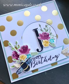 a happy birthday card with flowers and a number one on the front, sitting on top of a table