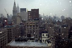 the city skyline is covered in snow as it sits on top of a tall building