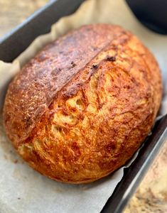 a loaf of bread sitting on top of a piece of wax paper in a pan