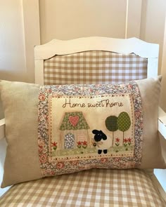 a pillow that is sitting on top of a chair next to a pillow with the words home sweet homes