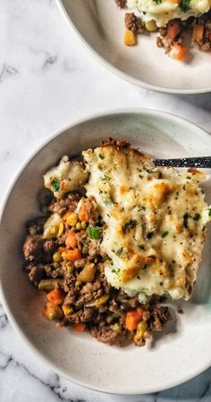 two white plates topped with different types of food