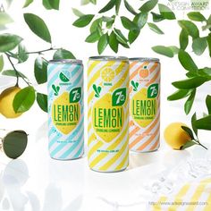 two cans of lemonade are sitting next to each other on a table with sunglasses