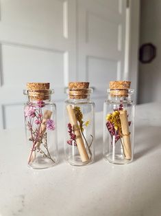 three glass jars with dried flowers in them