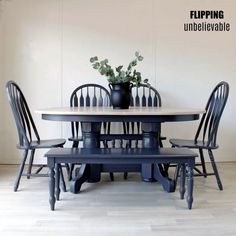 a dining table with four chairs and a potted plant on the top, in front of a white wall