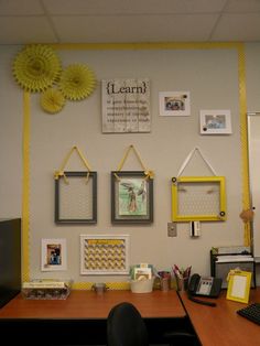 an office cubicle with yellow accents and pictures on the wall