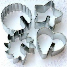 four heart shaped cookie cutters sitting next to each other on a white doily