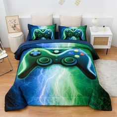 a bed covered in a green and blue comforter with two video game controllers on it