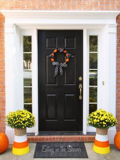 the front door is decorated with pumpkins and flowers