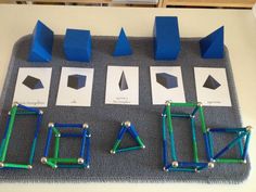 some blue and green objects are sitting on a gray mat with white squares around them