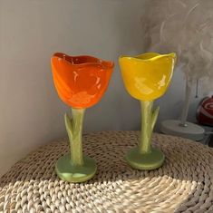 two glass vases sitting on top of a wicker table