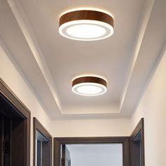 two circular lights are mounted on the ceiling above a door way in an empty room