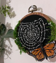 a butterfly sitting on top of a piece of grass next to a black and white net