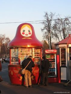 two people standing in front of a kiosk selling sodas and soft drinks