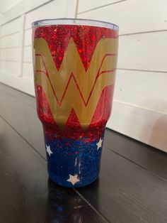 the wonder woman logo is painted on a cup with red, white and blue sprinkles