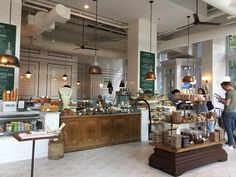 people are standing in front of the bakery counter