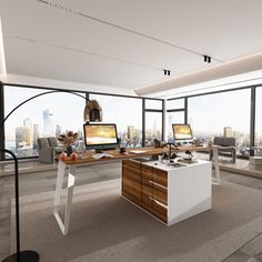 an office with two computer screens and desks in front of large windows overlooking the city