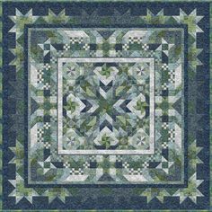 a quilt made with blue and green fabric, featuring an image of a square in the center