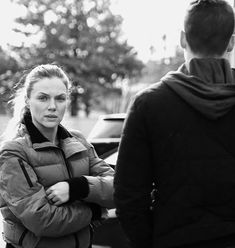 a woman standing next to a man on the street