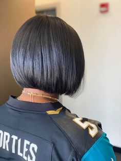 the back of a woman's head with short black hair wearing a jersey that says turtles